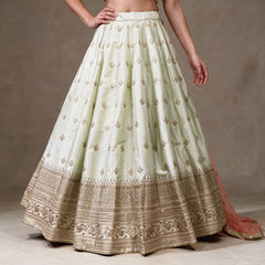 Pista green raw silk lehenga skirt with scattered gold butis and layered gold embroidered hem