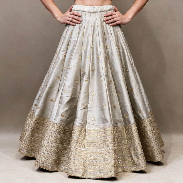 Silver grey raw silk lehenga skirt with scattered gold butis and layered gold embroidered hem