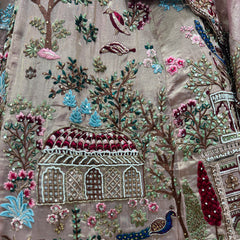 Embroidered lehenga fabric close-up with floral, tree, and temple motif details