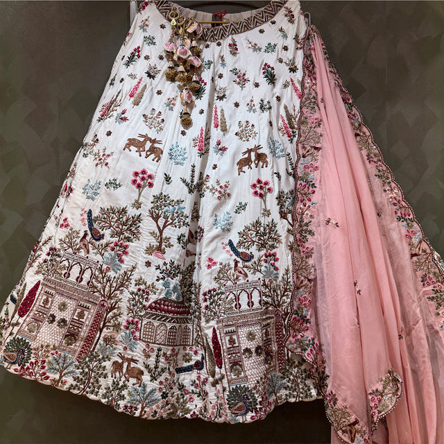 White lehenga with multicolor village motif prints and pink dupatta border