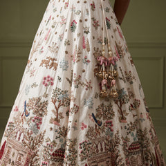 White lehenga skirt with multicolor floral and tree prints, ornate border trim