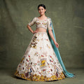 Ivory floral embroidered lehenga with short sleeves, full skirt, and blue draped dupatta