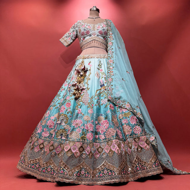Sky blue ombre lehenga with floral hand embroidery and ornate gold-trimmed skirt