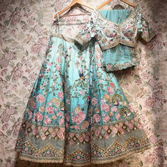 Sky blue floral lehenga dress on hanger with gold decorative border and full skirt