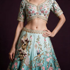 Embroidered cropped blouse and sky-blue ombre lehenga with floral motifs and peacock detail