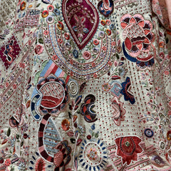 Ivory fabric with dense multicolour beaded motifs, mirror-like embellishments and embroidery
