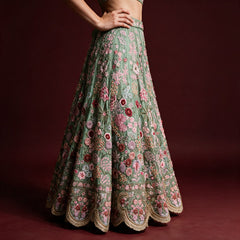 Sage green crape silk lehenga skirt with pink and burgundy rose clusters and scalloped hem, worn