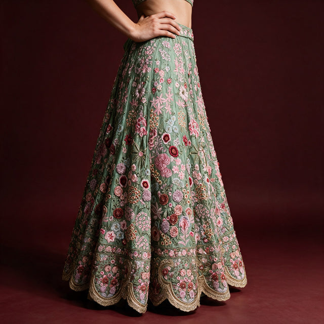Sage green crape silk lehenga skirt with pink and burgundy rose clusters and scalloped hem, worn