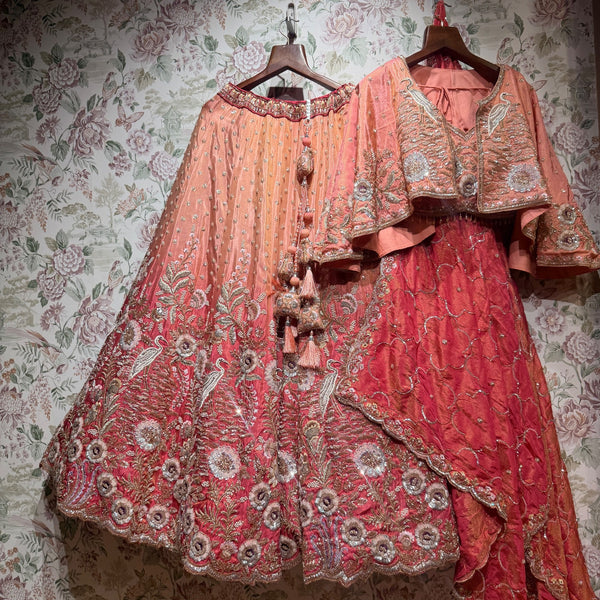 Set of peach coral ombre lehenga with embroidered poncho jacket and dupatta on hangers