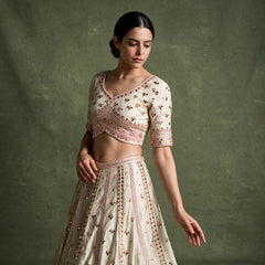 Close-up of the ivory cross-over blouse with pink embroidered band and cuffs, and the skirt with pink embroidery lines and mirror discs