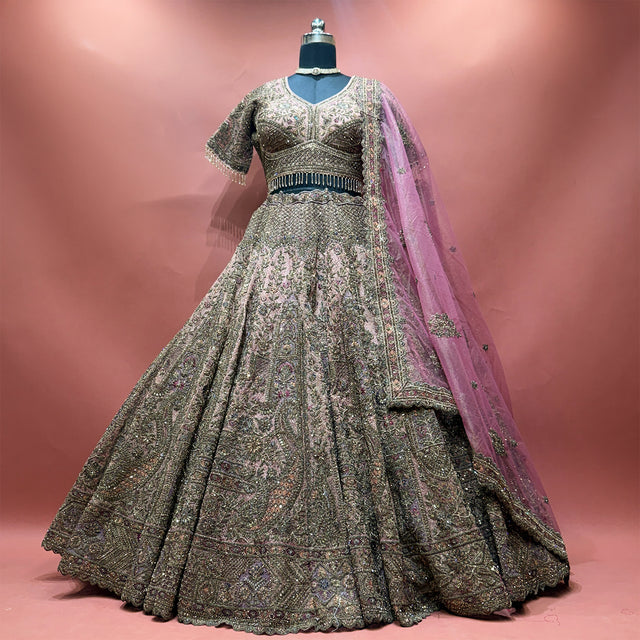 Dusty rose net lehenga set on a mannequin with antique zari paisley work, scalloped hem and mauve net dupatta