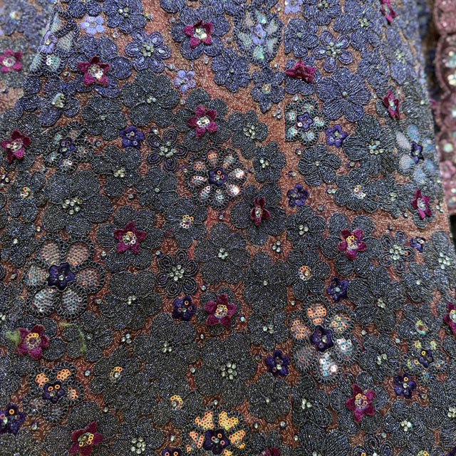 Embroidered net fabric close-up with multicolor sequins and glitter dori-style motifs