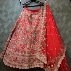 Red embroidered lehenga with intricate panel patterns, silver trim, and matching drape