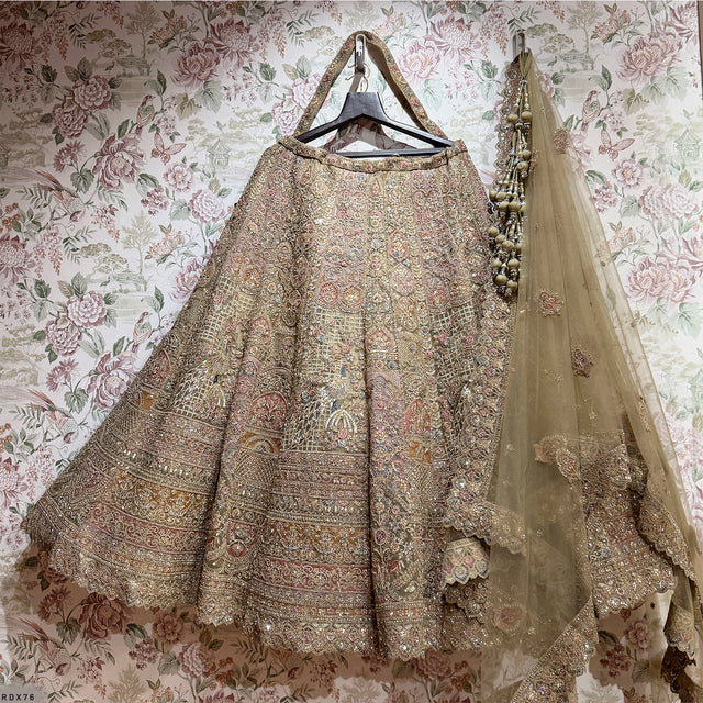 Sage green lehenga skirt with embroidered flared panels and sheer dupatta on hanger