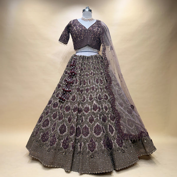 Maroon embroidered lehenga skirt with V-neck blouse and sheer dupatta, on mannequin