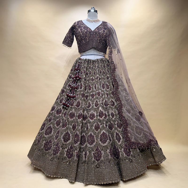 Maroon embroidered lehenga skirt with V-neck blouse and sheer dupatta, on mannequin
