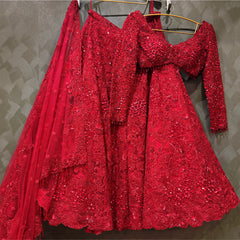 Red sequined bridal lehenga dress with cropped neckline and layered flare skirt on hanger