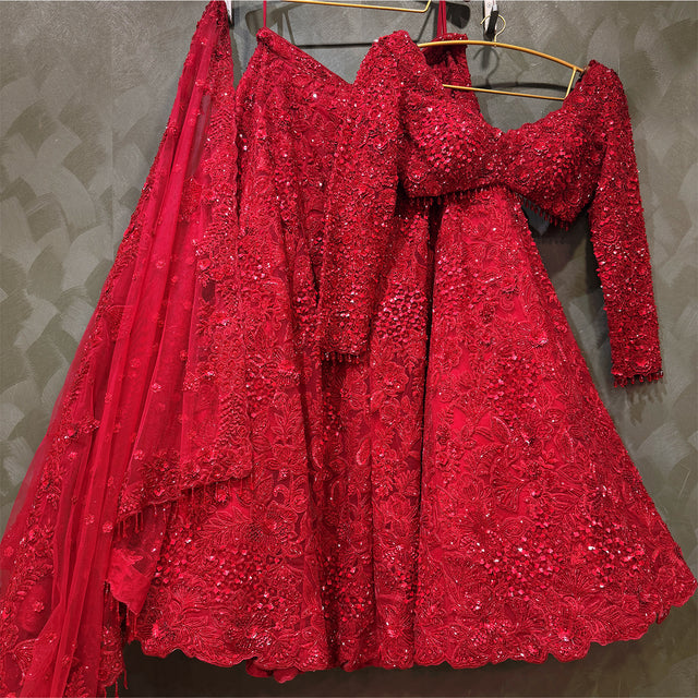 Red sequin lehenga with full skirt and long-sleeve blouse on hangers