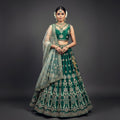 Deep green lehenga with gold-cream embroidery and sheer dupatta, matching choli