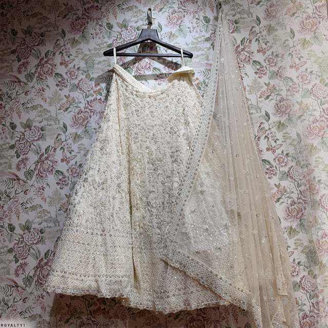 Off-white embellished lehenga with sheer dupatta draped over the shoulder