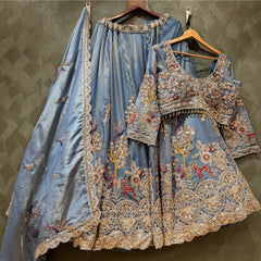 Embroidered blue lehenga skirt and matching full-sleeve blouse on hangers