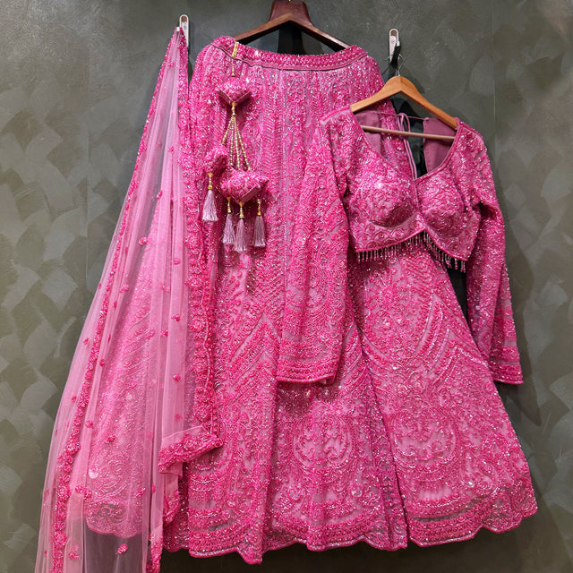 Shocking pink beaded lehenga with matching blouse and sheer dupatta, tiered skirt