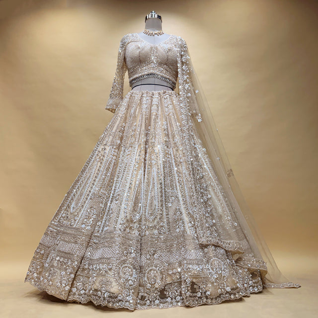 Ivory beaded lehenga on mannequin with fitted bodice, flared skirt, and sheer dupatta
