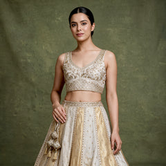 Offwhite lehenga top and skirt with gold embroidered V-neck sleeveless blouse and belt