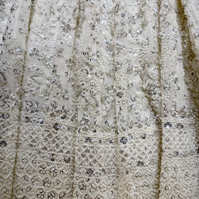 Close-up of off-white floral vine embroidery with sequins and beads