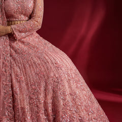 Close-up of baby pink lehenga skirt with beadwork, sequins, and floral motifs