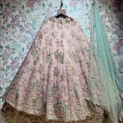 Baby pink flared lehenga with ornate multicolor floral embroidery hem and matching teal dupatta