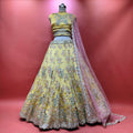 Embroidered yellow lehenga set with flared skirt, matching blouse, and pink sheer dupatta