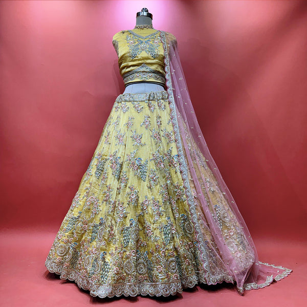 Embroidered yellow lehenga set with flared skirt, matching blouse, and pink sheer dupatta