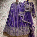 Purple raw silk lehenga with full sleeves, heavy embroidery border and scalloped hem