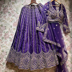 Purple raw silk lehenga with embroidered floral lines and scalloped hem, embroidered blouse and net dupatta on hangers