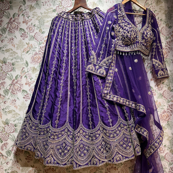 Purple raw silk lehenga with full sleeves, heavy embroidery border and scalloped hem