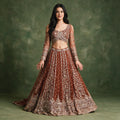 Rust embellished lehenga with flared skirt and matching stitched long-sleeve blouse