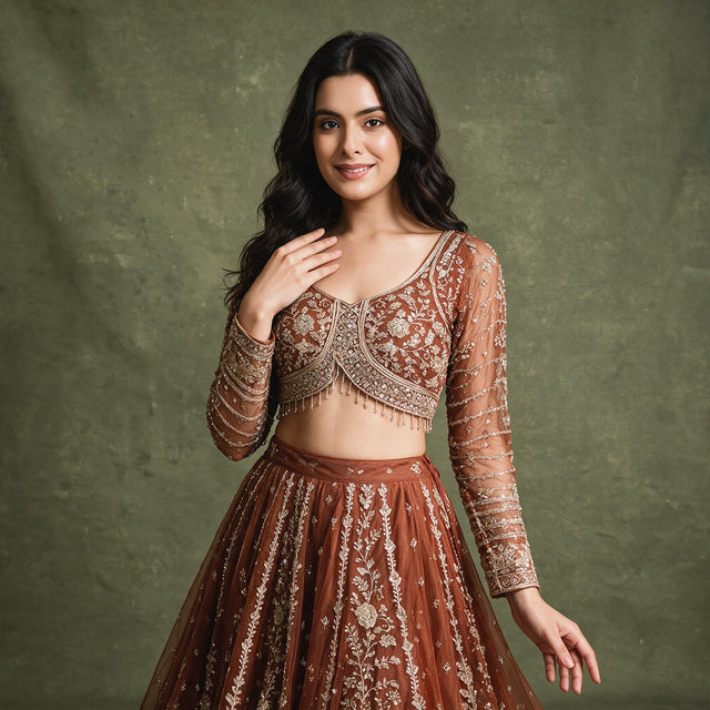Rust embroidered cropped blouse with long sleeves and detailed neckline over lehenga