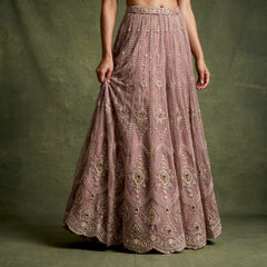 Close-up of the mauve lilac net lehenga skirt with vertical bead lines, hanging tassel motifs and stone-set medallions along the hem