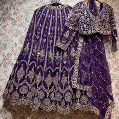 Purple net lehenga, embroidered full-sleeve blouse and purple net dupatta with a gold lattice on hangers against floral wallpaper