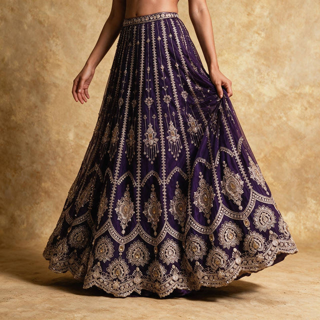 Close-up of the purple net lehenga skirt in motion, with vertical bead lines, hanging tassel motifs and stone-set gold medallions along the hem