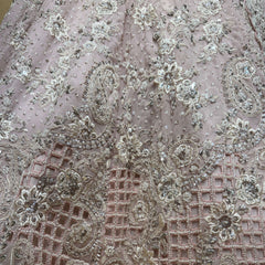 Close-up of soft pink georgette lehenga fabric with silver-toned pearl cutdana work