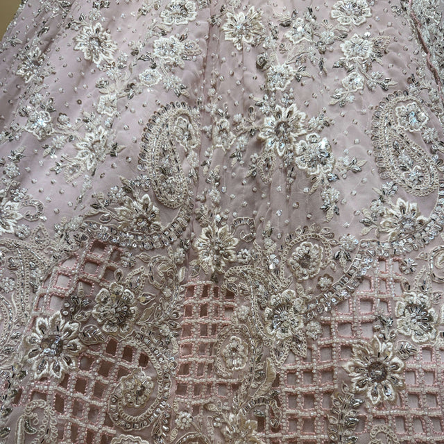 Closeup of pearl, cutdana and sequin embroidery on soft pink lehenga fabric