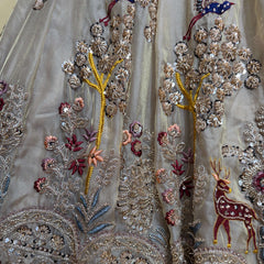 Close-up of lehenga fabric embroidery: silver beads with multicolor flowers, vines, and bird motifs