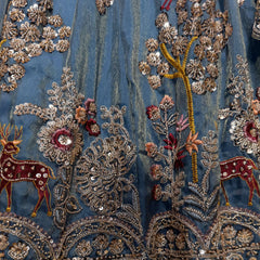 Close-up of blue lehenga fabric with gold, red, and silver sequin and thread embroidery