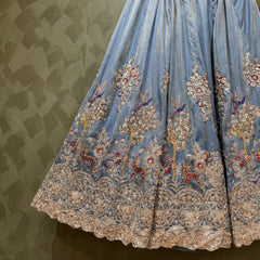 Light blue pleated lehenga skirt with gold trim and multicolor floral embroidery