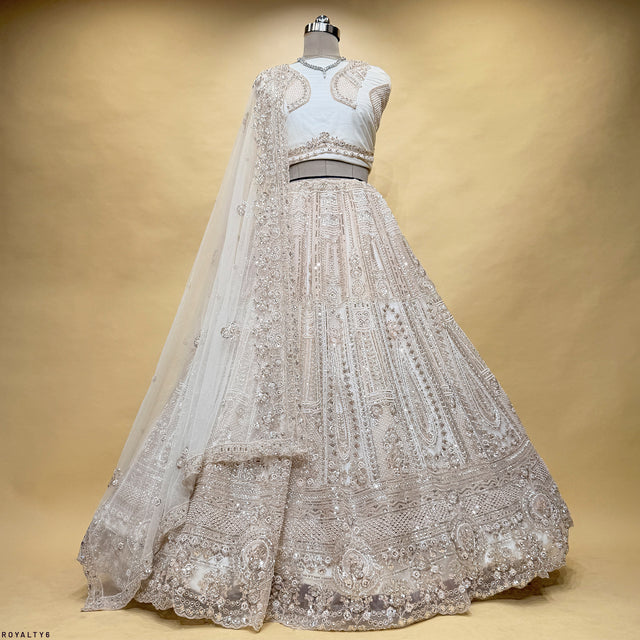 Pearl-white embroidered lehenga on mannequin with sheer dupatta and belt detail