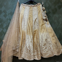 Offwhite and gold lehenga with vertical motif detailing, scalloped hem, and net dupatta