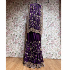 Deep purple crepe saree with gold cutdana work and ornate border, full-length drape.