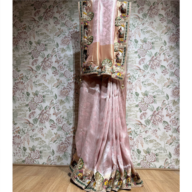Blush pink viscose silk saree with ornate figurative thread-work border and pleated drape